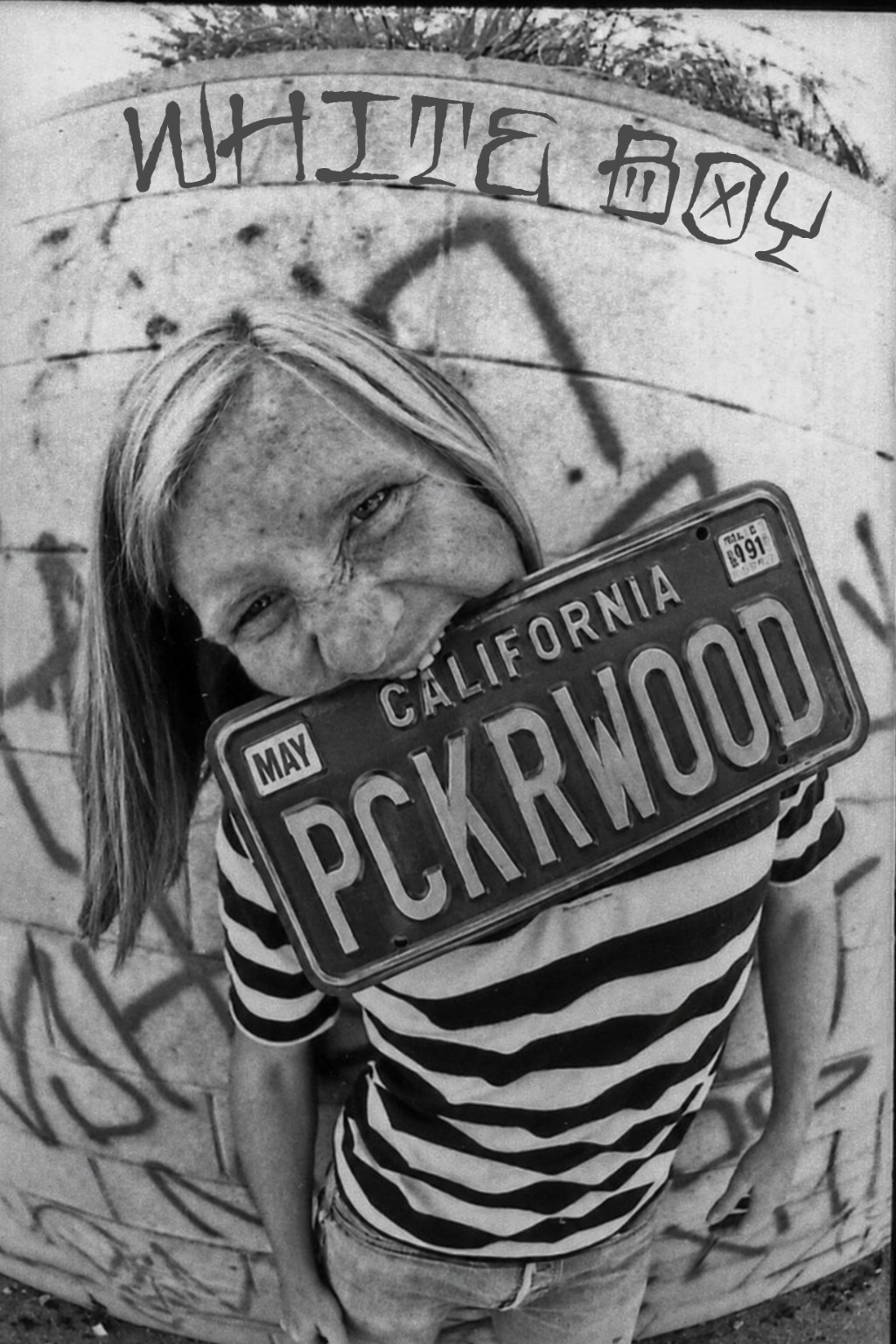Blonde kid holding a California PCKRWOOD license plate